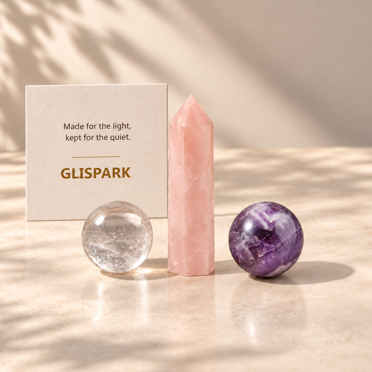GLISPARK Soft Dream Crystal Set with a rose quartz tower, clear quartz sphere, and Dream Amethyst sphere on a warm stone surface.